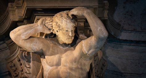 Einer der mächtigen Steinatlant in der Sala terrena des Stiftes, der die Arme zur Decke gehoben hat. 