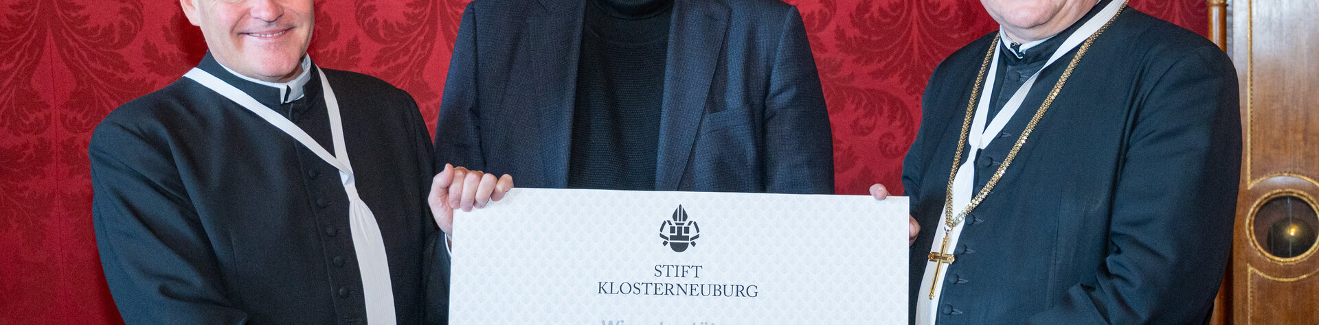 Stiftskämmerer Elias Carr Can.Reg., Kindernothilfe-Österreich Geschäftsleiter Gottfried Mernyi, Propst Anton Höslinger Can.Reg. halten gemeinsam einen symbolischen Scheck