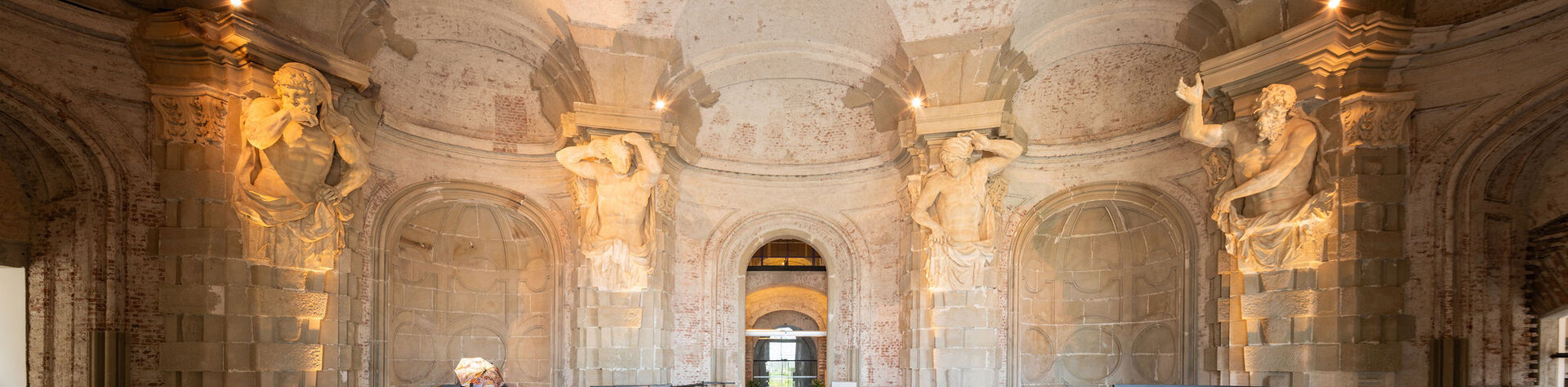 Blick vom Eingang in die Sala terrena des Stiftes Klosterneuburg mit den mächtigen Atlanten die die Decke tragen.