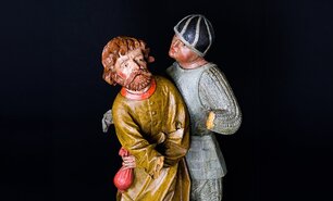 Farbige Holzskulptur aus 1500: von Judas und ein Scherge mit einem roten Geldbeutel